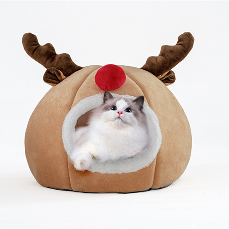 Cat resting inside a Christmas reindeer cat cave bed with plush antlers and red nose