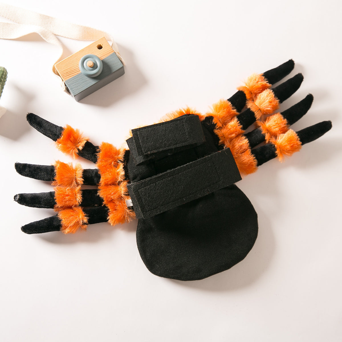 Dog spider costume laid flat, showing the plush black body and orange leg detail